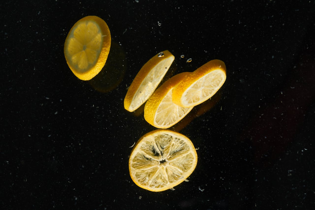 Floating lemon slices on dark water create a vibrant contrast and refreshing visual.